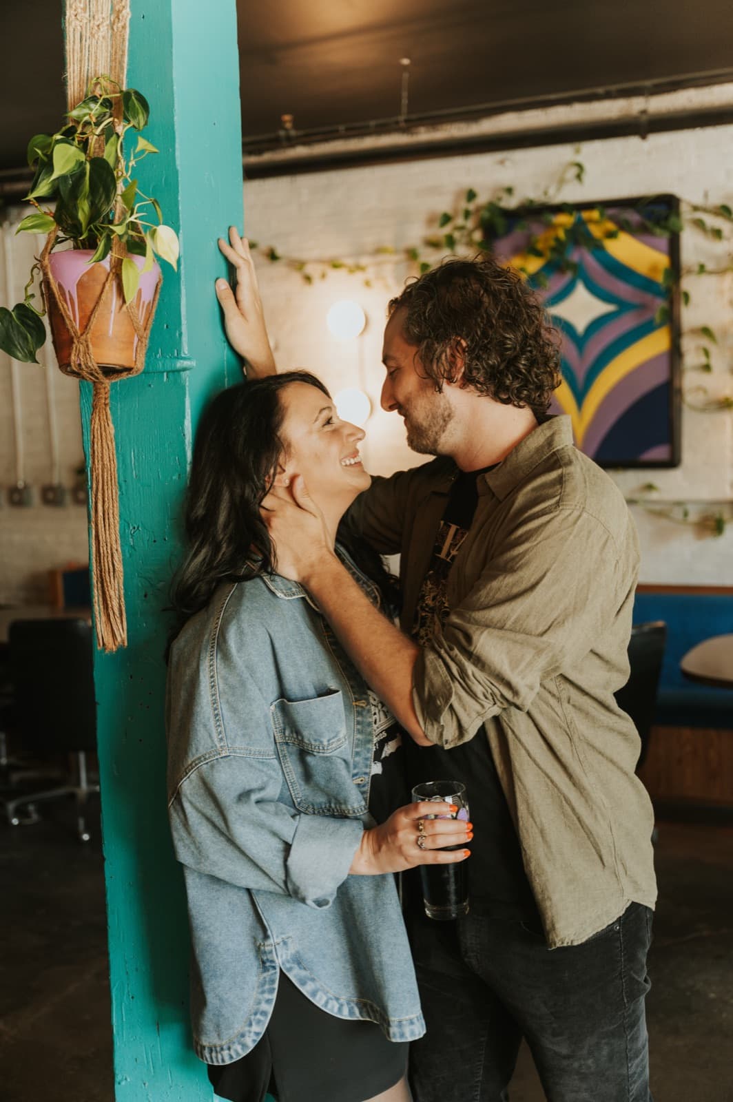 Derek and Shannon holding each other in front of a teal wall