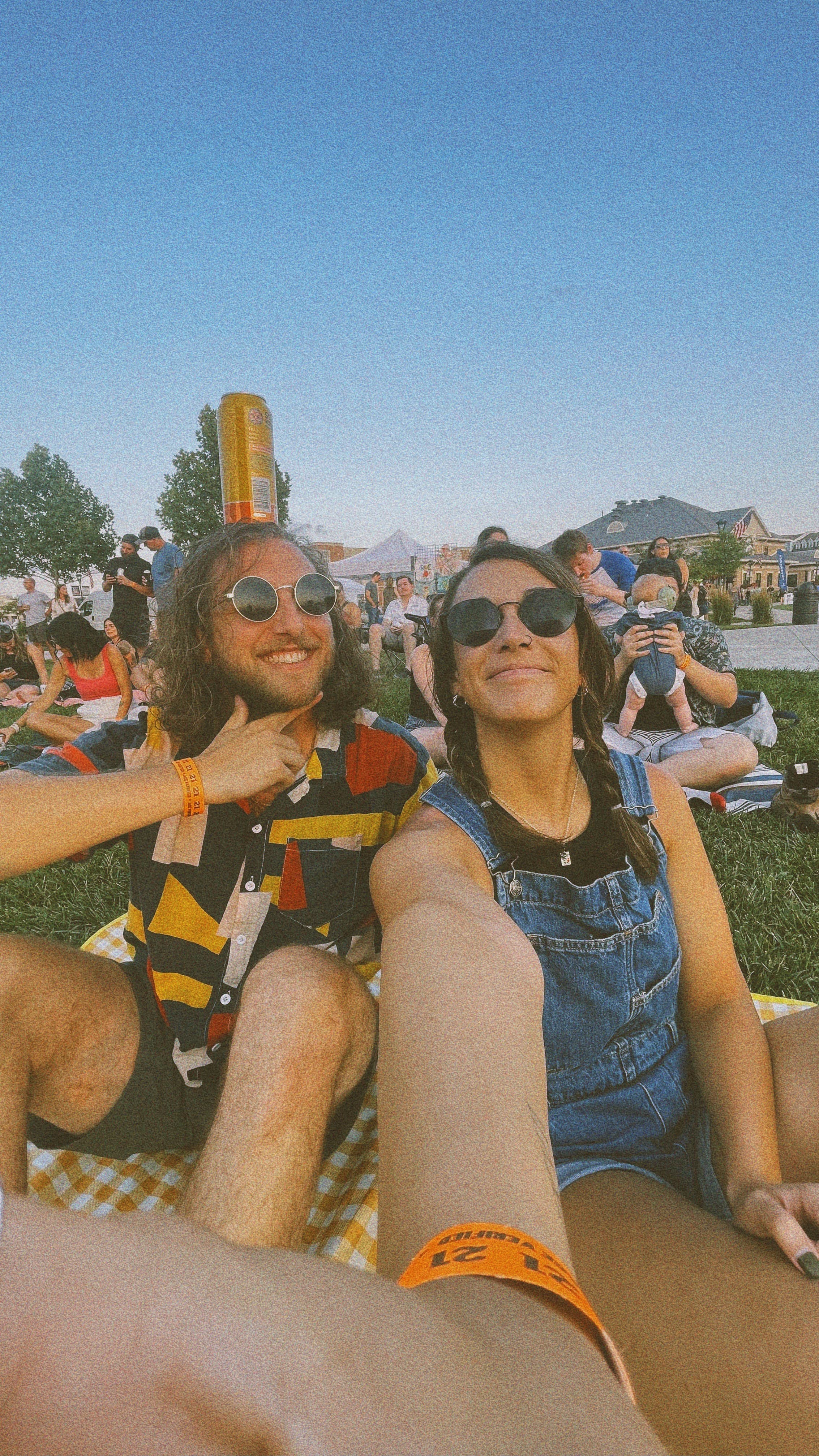Derek and Shannon smiling for a rain-soaked selfie at a festival